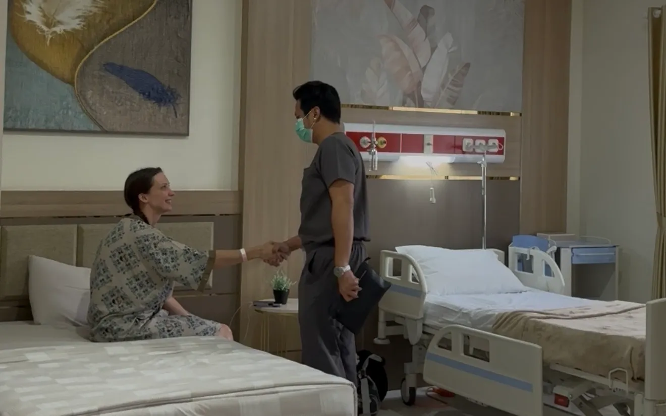 Doctor visiting patient in hospital room providing reassurance
