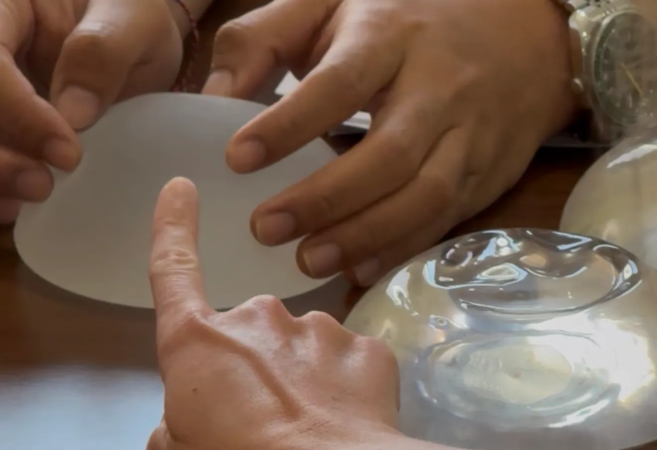 Surgeon and patient examining implant materials and profiles